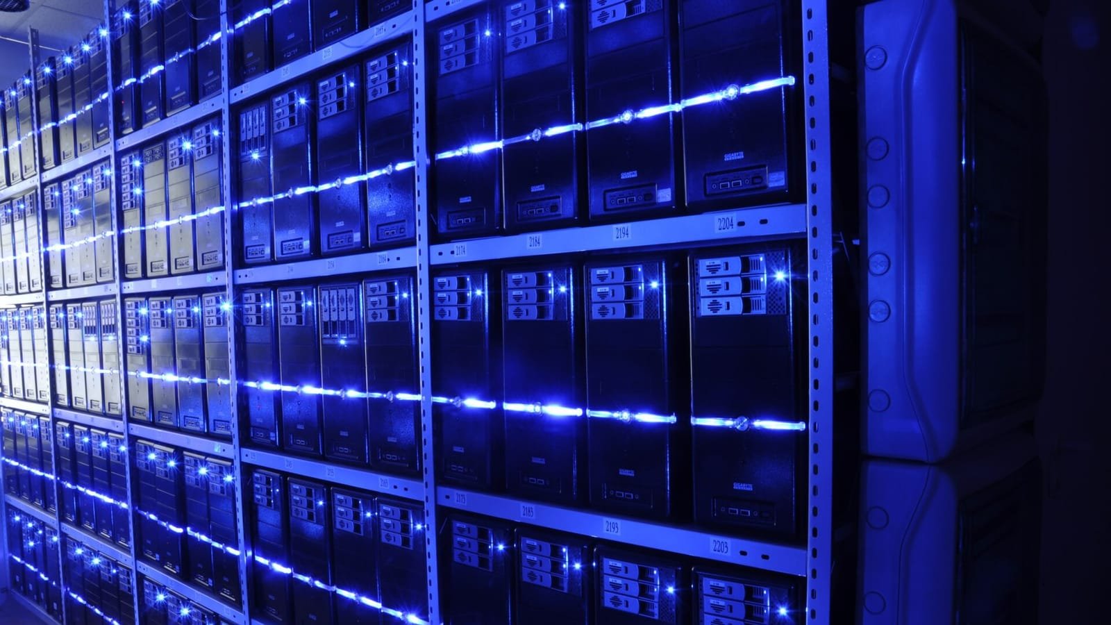 Pared de torres de servidores iluminada con tiras de luz azul en un centro de datos